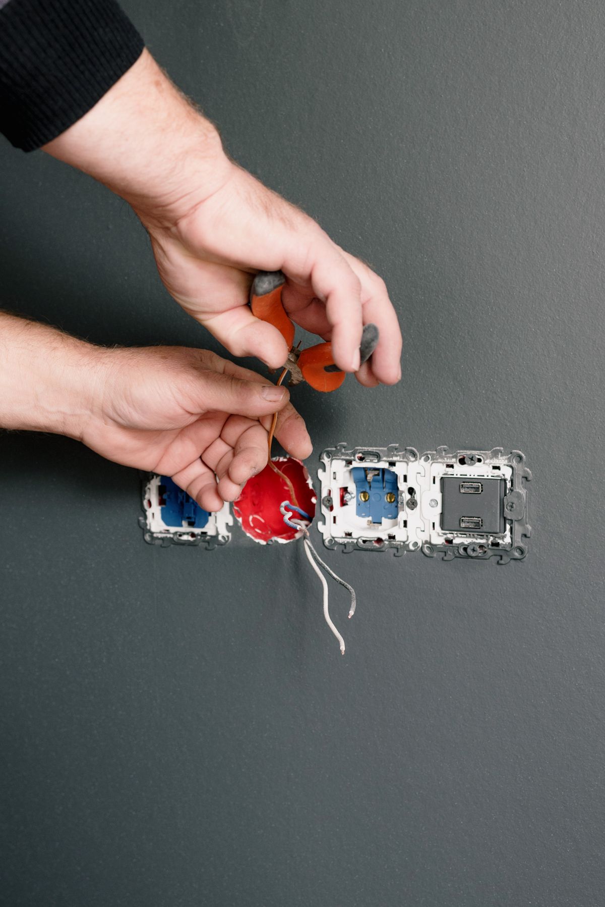 Electrician installing a wall outlet